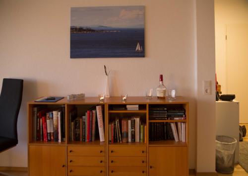 a wooden book shelf with books and a bottle of wine at 129 - Ferienwohnung am Südstrand in Wilhelmshaven