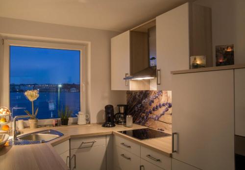 a kitchen with a sink and a window with a view at 129 - Ferienwohnung am Südstrand in Wilhelmshaven