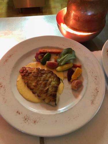 a white plate with a piece of food on a table at Hôtel La Bastide in Hyères