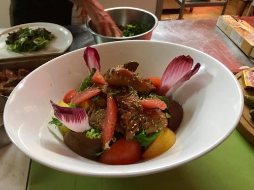 a bowl of food with meat and vegetables on a table at Hôtel La Bastide in Hyères