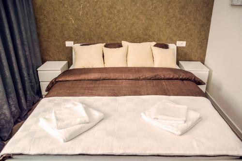 a bedroom with a bed with two white towels on it at Hotel MOREA in Ljubljana