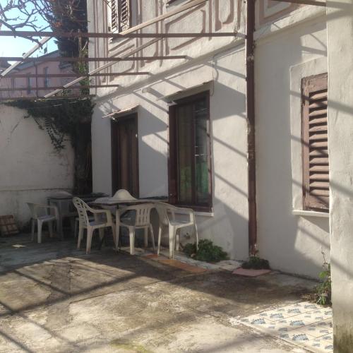 une table et des chaises assises à l'extérieur d'un bâtiment dans l'établissement G.VERGA 22, à Trieste