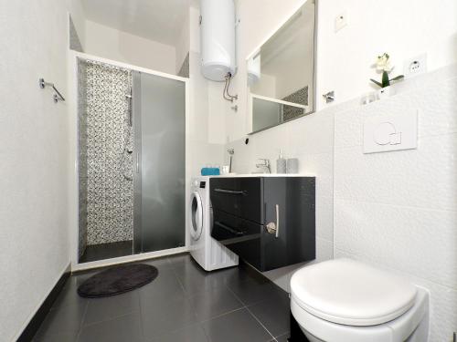 une salle de bain blanche avec toilettes et douche dans l'établissement Apartment Arya, à Makarska