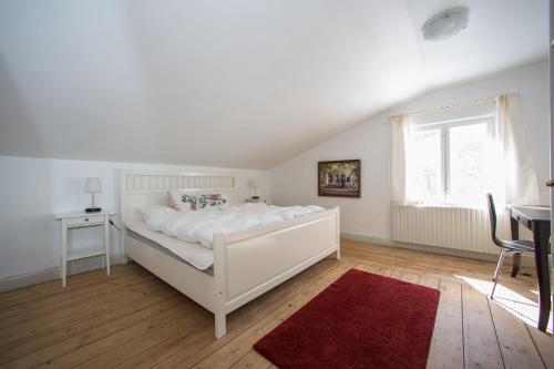 博雷的住宿－The Lodge，卧室配有白色床和红色地毯