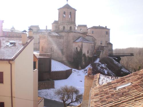an old castle with snow on the roofs of buildings at Rincón del Nazareno in Almazán