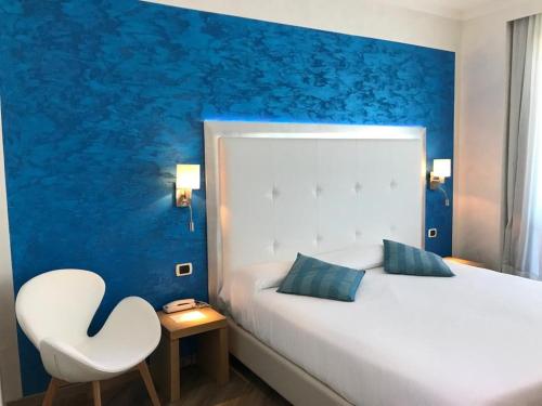 - une chambre avec un lit blanc et une chaise blanche dans l'établissement Hotel Europa, à Padoue