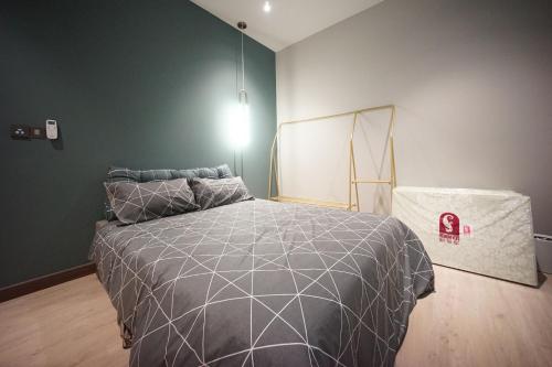 a bedroom with a bed with a gray comforter at 5min Permas@CIQ@CS@3R2B@Green Haven in Masai