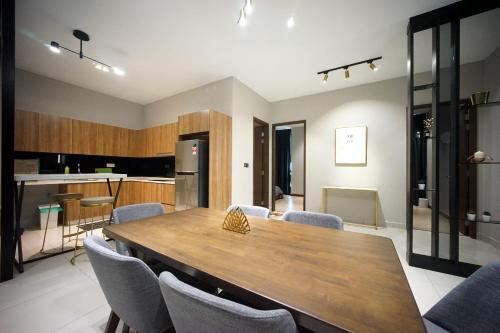 a kitchen and dining room with a wooden table and chairs at 5min Permas@CIQ@CS@3R2B@Green Haven in Masai