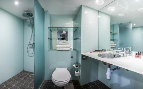 a bathroom with a toilet and a sink and a mirror at pentahotel Warrington in Warrington