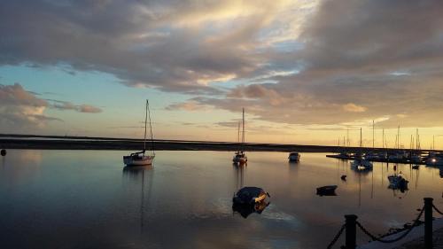 a group of boats in the water at sunset at Apartamento Parque Ria Formosa, Olhão in Olhão