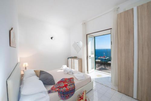 Cette chambre blanche comprend un lit et offre une vue sur l'océan. dans l'établissement Casa Cetrangolo, à Praiano