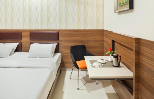 een hotelkamer met 2 bedden en een tafel bij Ananyas Nest in Coimbatore