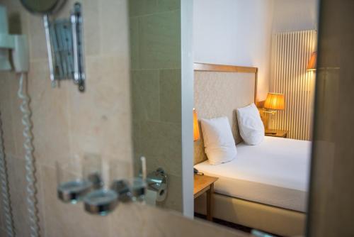 a hotel room with a bed and a shower at Hotel The Lord in Ghent