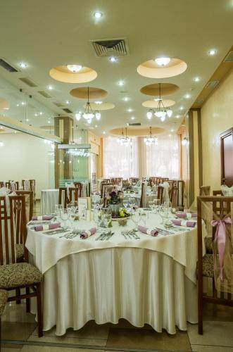 a dining room with a long table with white table cloth at Hotel Traian in Brăila