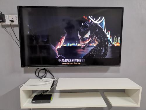 a flat screen tv sitting on top of a white stand at DT Homestay floor level 4 in Malacca