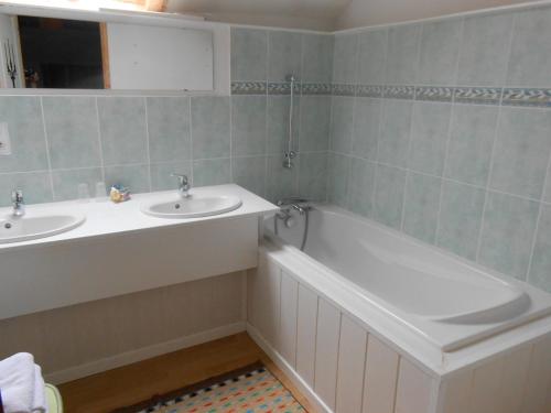 a bathroom with two sinks and a bath tub at Le Logis du Pré Braheux in Saint-Nabord