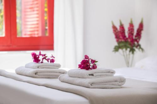 4 toallas con flores en el mostrador del baño en Liora Suite, en Protaras