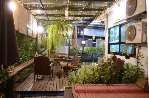 a patio with a table and chairs and plants at Early Bird Hostel Ayutthaya in Phra Nakhon Si Ayutthaya