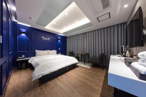 a bedroom with a bed and a blue wall at Stay Hotel in Gwangju