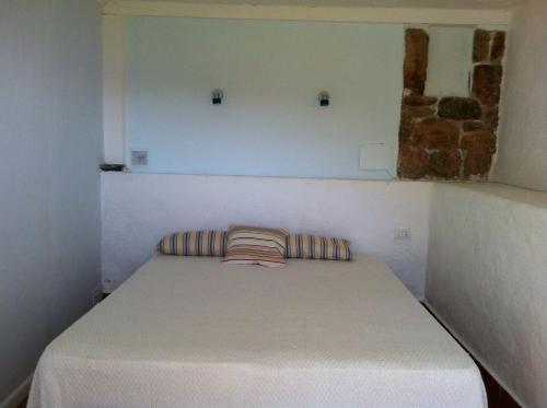 un piccolo letto con due cuscini in una stanza di Oasi nel Verde a Golfo Aranci