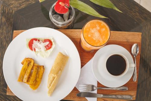 une table avec une assiette de nourriture et une tasse de café dans l'établissement Country Club Eco Casajardin, à Moyobamba