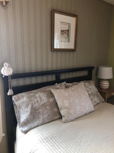 a bed with two pillows and a picture on the wall at Auberge d'Anjou-Sūrya Café in Petit Rocher