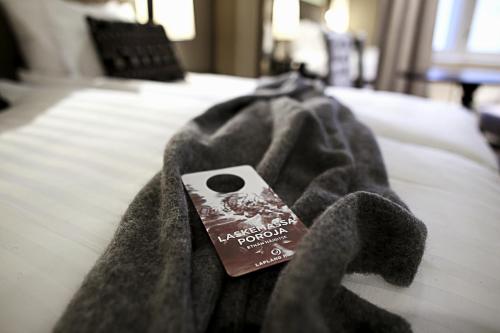 a book sitting on top of a bed with a blanket at Lapland Hotels Kuopio in Kuopio