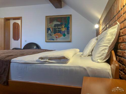 a bedroom with a bed with white sheets and pillows at Villa Vodno in Skopje