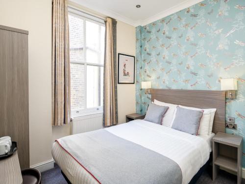 um quarto de hotel com uma cama e uma janela em OYO Bakers Hotel London Victoria em Londres