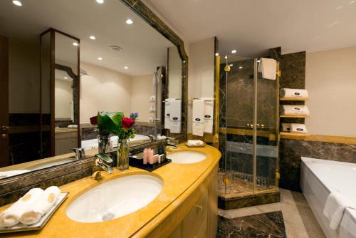 a bathroom with two sinks and a shower at Swiss Diamond Hotel & Spa in Morcote