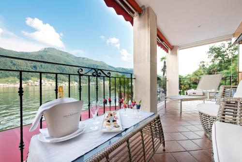 a table on a balcony with a view of the water at Swiss Diamond Hotel & Spa in Morcote
