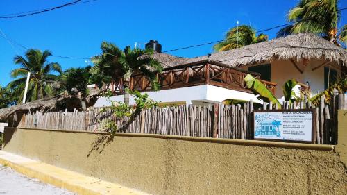 a house with a fence and a sign in front of it at La Casa del Ritmo in El Cuyo