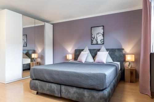 um quarto com uma cama grande e paredes roxas em Wohnen auf Zeit - Innenstadt-Appartements em Friburgo em Brisgóvia