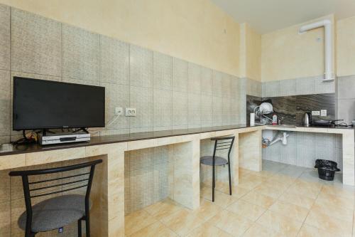 a kitchen with a bar with two chairs and a flat screen tv at Pechersk House in Kyiv