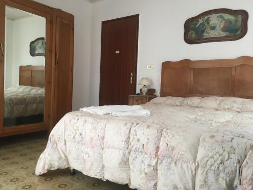 1 dormitorio con 1 cama grande y espejo en Casa Salvaggio, en Grotte