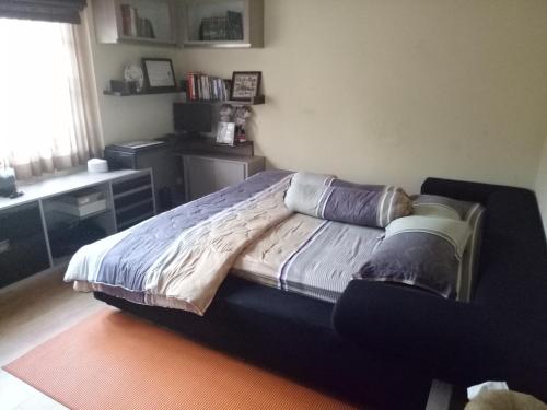 萬隆的住宿－Homestay Syariah Cileunyi, Bandung Timur，一间卧室配有一张带书桌的床和窗户。