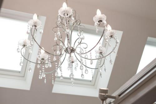 a chandelier hanging from a ceiling in a room at Hotel Zur Linde Dein Self Check In in Michendorf