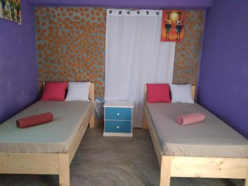 two beds in a room with purple walls at Ciza e Rose in Portela