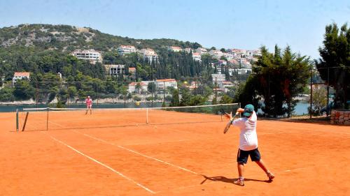 two people playing tennis on a tennis court at Hotel Splendid in Dubrovnik