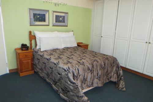 a bedroom with a bed with a bedspread on it at Lajava Guest Lodge in Krugersdorp