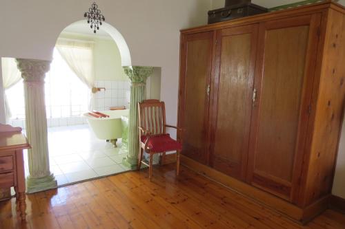a bathroom with a tub and a chair in a room at Lajava Guest Lodge in Krugersdorp