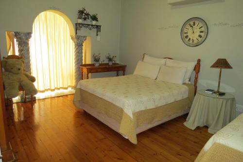 a bedroom with a bed and a clock on the wall at Lajava Guest Lodge in Krugersdorp