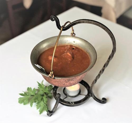 a metal pot of soup on a table at Šiker B&B Hotel in Pernica