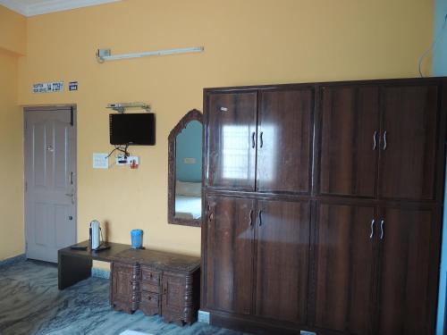 a room with a large wooden cabinet and a mirror at Radha Party Hall in Kanchipuram