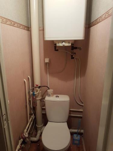 a small bathroom with a toilet and a tank at Apartment on Y. Mudroho 44 in Bila Tserkva