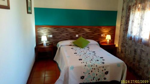 Schlafzimmer mit einem Bett mit grünem Kopfteil in der Unterkunft Hostal de la Villa Molinos in Molinos
