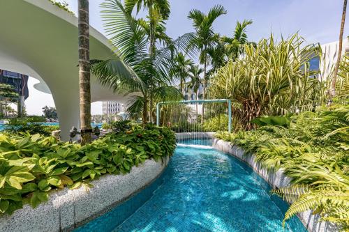 a swimming pool in a resort with palm trees at Village Hotel Sentosa by Far East Hospitality in Singapore