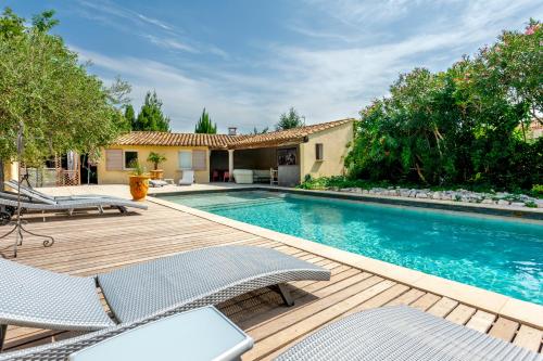 una piscina con sillas y una casa en Mas De L'ilon, en Vallabrègues