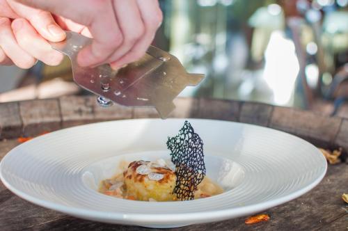 a person is pouring sauce onto a plate of food at Hotel Marina in Izola