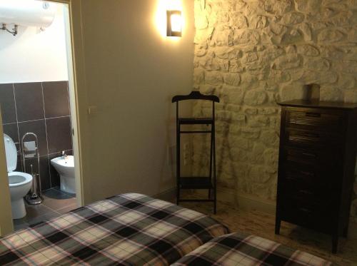 sypialnia z łóżkiem i kamienną ścianą w obiekcie Apartamentos Rurales La Villa de Piedra w mieście Cartes